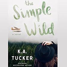 A book cover with a photo image of a person facing away from the camera, hand holding her hat onto her head, looking out at a forest of trees and a plane in the sky. The title, The Simple Wild, is written in brushstroke font in the sky. The author is K. A. Tucker.